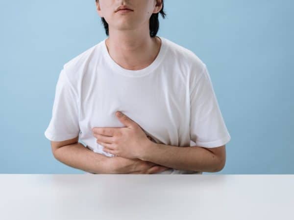 Man in White Shirt Suffering from a Stomach Pain