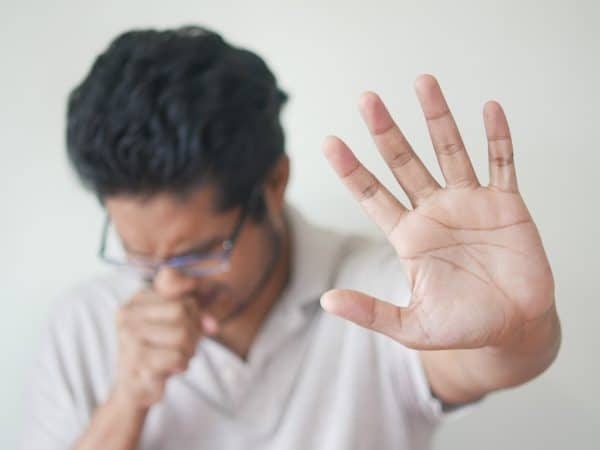 a man holding his hand up in front of his face